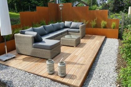 Gartengestaltung mit Holzboden und Sichtschutz aus Stahl 